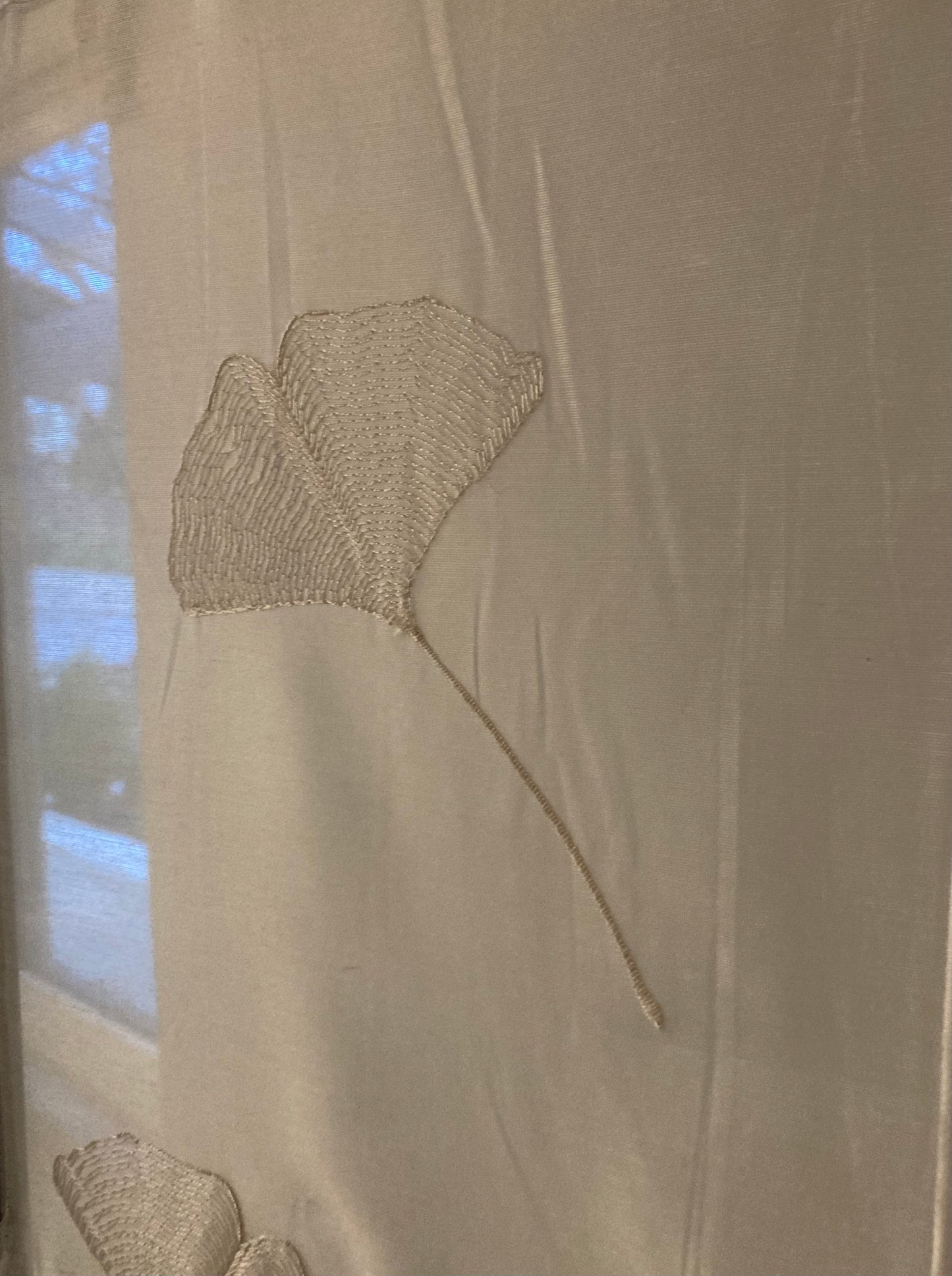 Sheer fabric with embroidered Ginko Leaf motif. White color. Sheer fabrics allow light to filter through